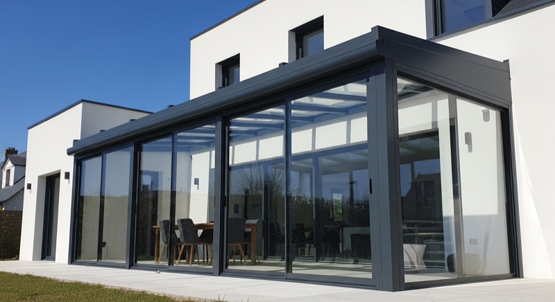 Véranda aluminium contemporaine à profilés gris anthracite sur une maison moderne